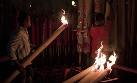 Một công nhân mang thắp những cây nhang khủng tại một ngôi đền ở Kuala Lumpur, Malaysia
