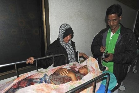 Người thân gia đình nạn nhân đứng bên thi thể một em bé