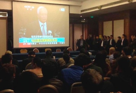 Thân nhân hành khách trên MH370 ngất xỉu trong buổi họp báo - 1 Thân nhân hành khách mất tích theo dõi công bố của thủ tướng Malaysia qua TV