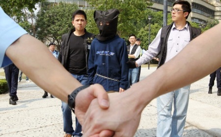 Hồng Kông xét xử kẻ sát hại bố mẹ dã man - 1 Cảnh sát áp giải Henry Chau tới tòa án