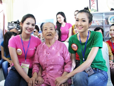 các người đẹp ân cần nắm tay và cùng ghi hình lưu niệm với các cụ ở Trung tâm