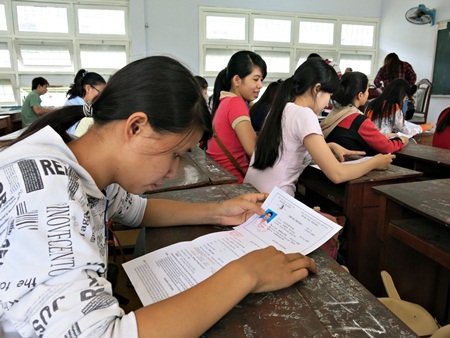 Thí sinh kiểm tra lại giấy tờ dự thi theo hướng dẫn của cán bộ coi thi. (Ảnh: Khánh Hiền)