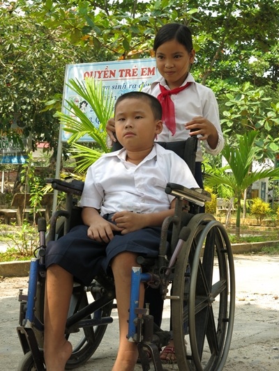 Em Ngô Thị Kim Huy (HS lớp 5/1) giúp đẩy xe lăn đưa đón Bảo Tân đến trường mỗi ngày