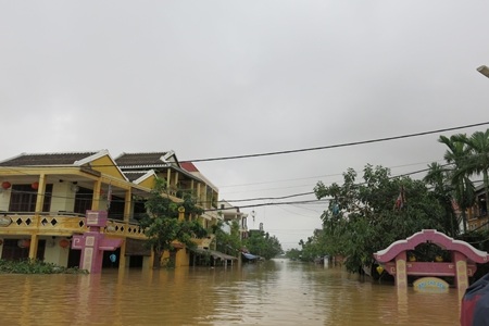 Du khách cũng bình thản ngồi quán ngắm phố dù nước ngấp nghé thềm nhà