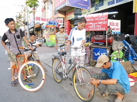 Coi các cháu học sinh cũng như con cháu mình nên ông Hùng bơm vá xe miễn phí.