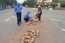 Thanh tra GTVT Hà Nội cùng người dân dọn gạch vỡ rơi vãi trên đường