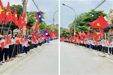 Người dân đứng 2 bên đường cầm quốc kỳ đón các liệt sỹ về đất mẹ