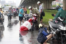 Đang đi trên đường, dừng xe để mặc áo mưa có phạm luật không?