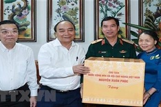 State President visits families of contributors to national reunification in Hanoi