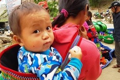 Children carried by mothers at Bac Ha Market