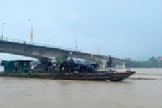 Drifting Chinese dredgers on the Red River brought ashore