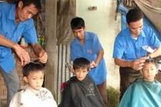 Volunteers give haircuts to needy people and students