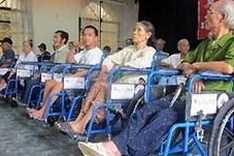International NGOs present wheelchairs to disabled people