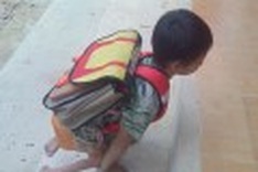 Handicapped boy walks on his hands to school